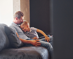 man and son sitting on a couch