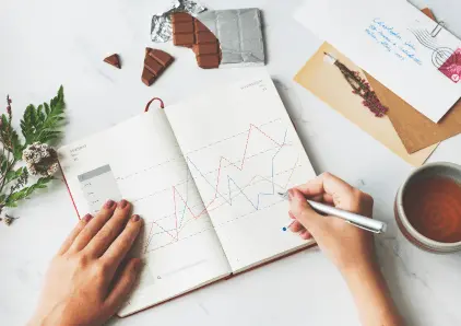 open notebook with a hand drawing trending up